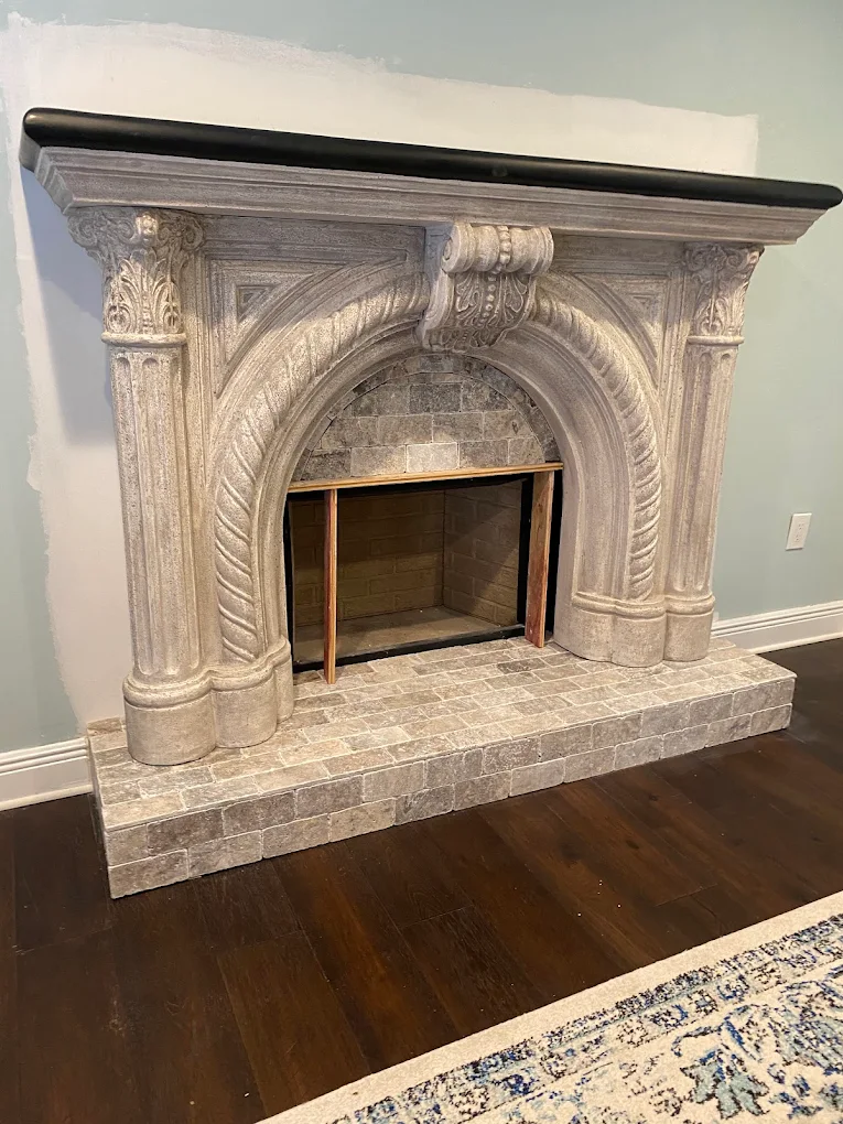 Hand-finished ornate cast stone fireplace surround restoration