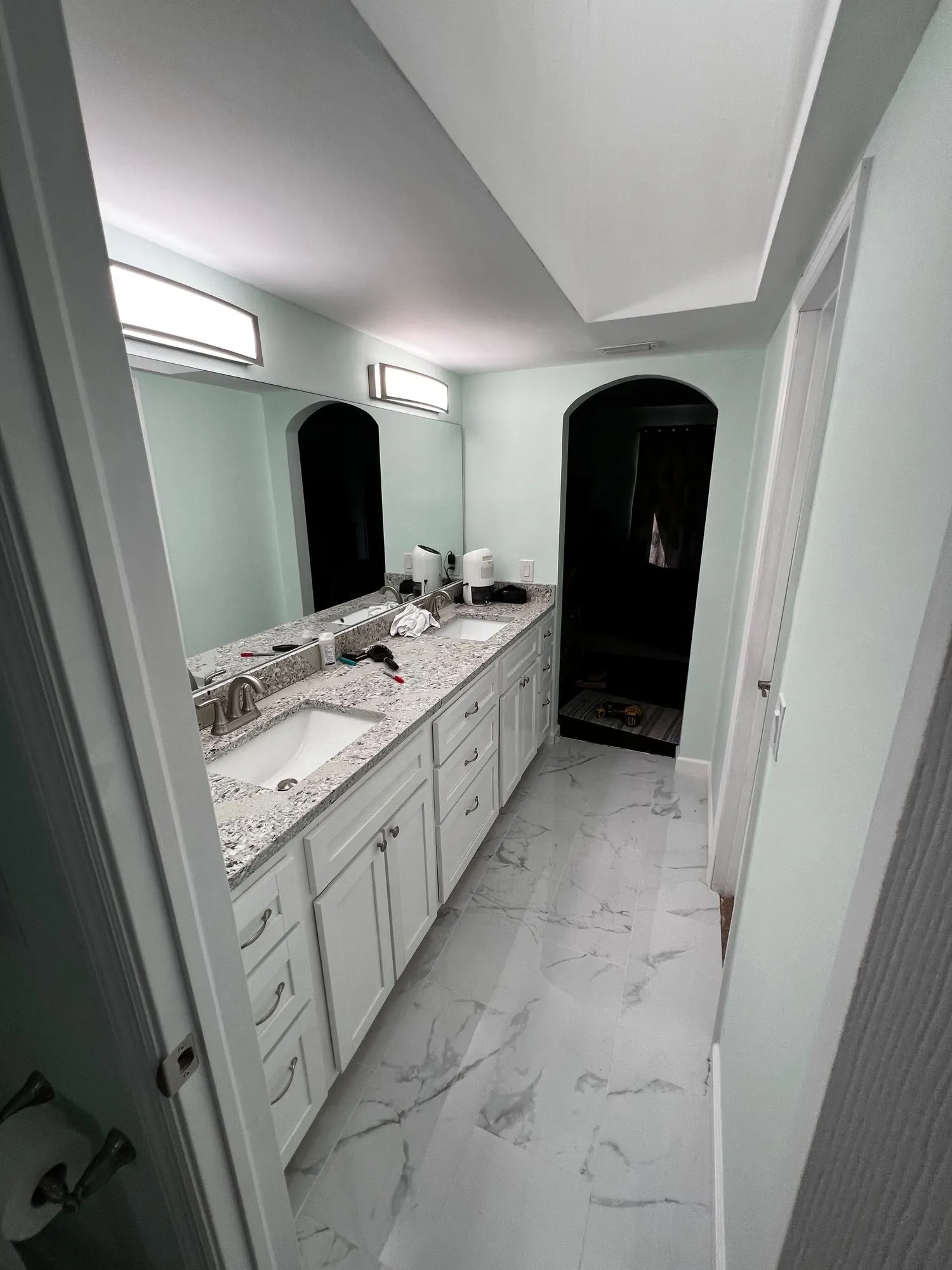 Walk-in tile shower with pebble floor and niche
