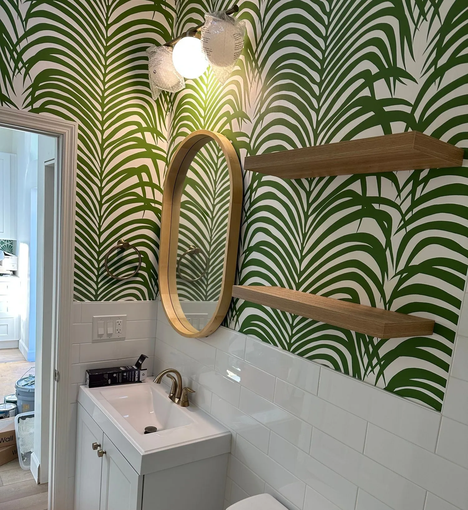 Powder room remodel with bold wallpaper and floating vanity